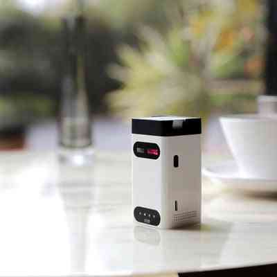 Compact LEING FST Virtual Laser Keyboard Bluetooth Projector placed on a table, featuring a sleek white and black design.