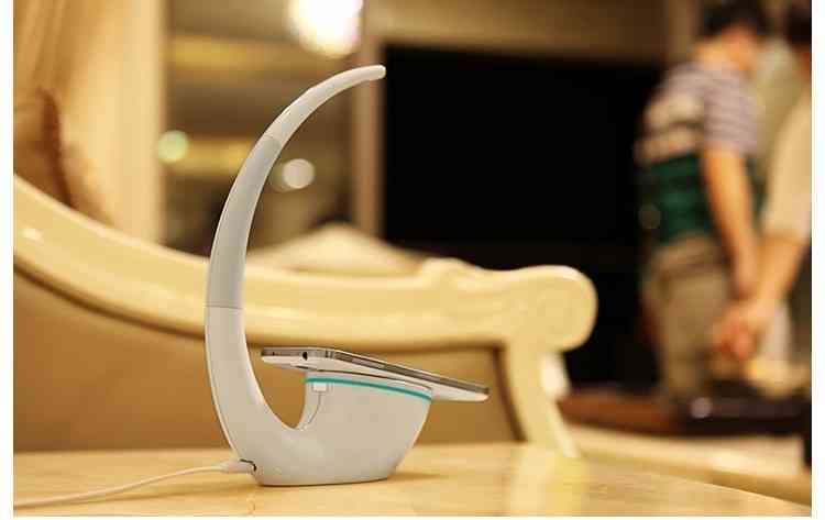 Phantom wireless charger lamp in a cozy living space, featuring a futuristic curved design with touch control and wireless charging functionality.