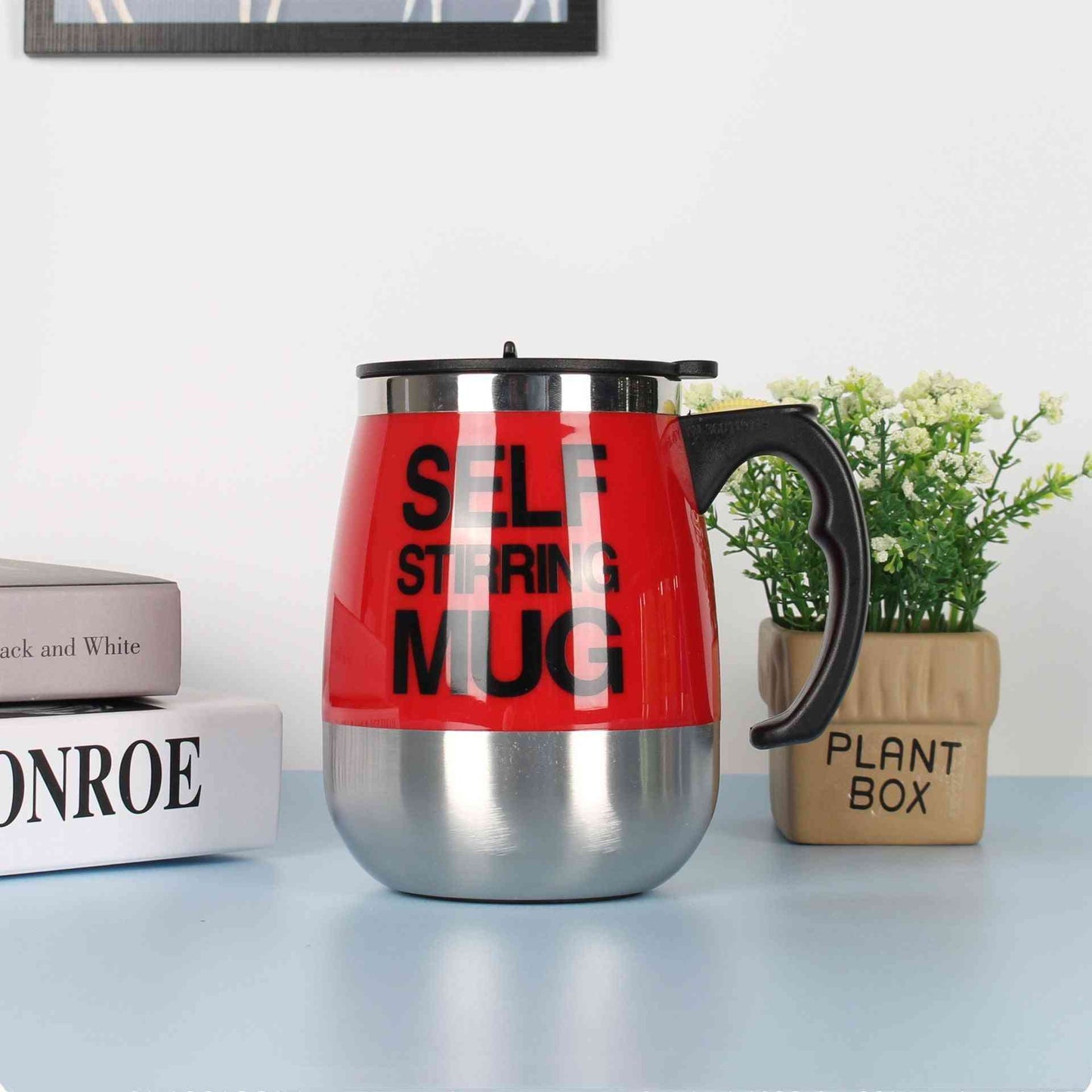 Scarlet red self-stirring electric coffee mug with stainless steel bottom and black handle, designed for effortless beverage mixing.